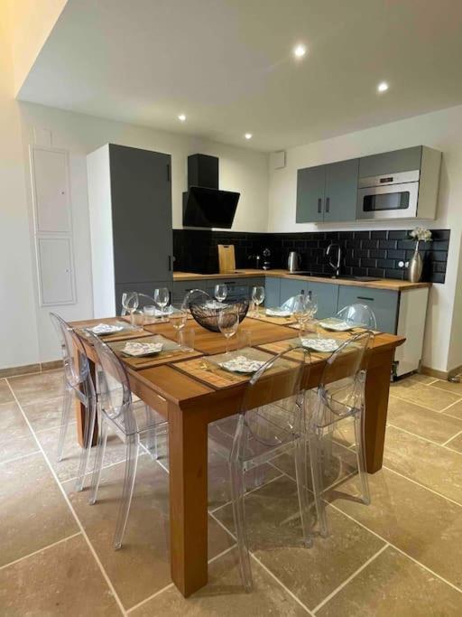 une table en bois dans une cuisine avec des chaises autour de celle-ci dans l'établissement Maison Meursault parking fermé, à Meursault