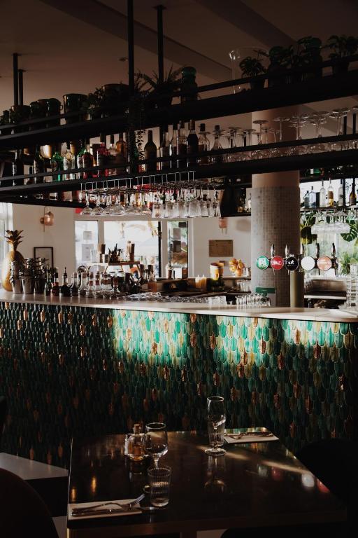 a bar with a black and green wall at Le Rose Thé in La Ciotat