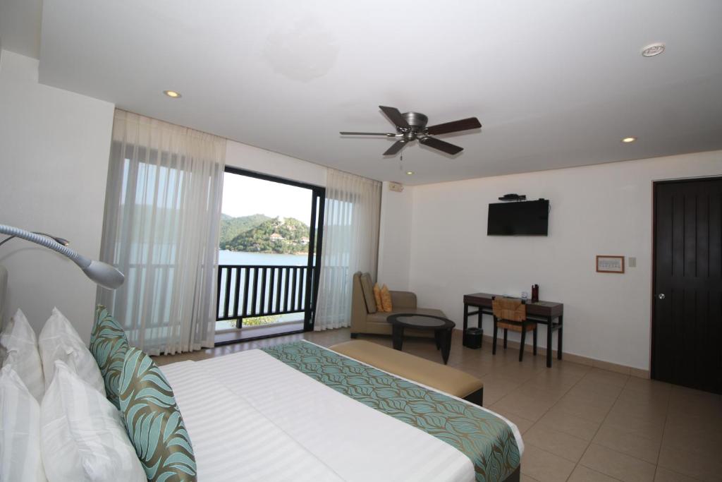 ein Hotelzimmer mit einem Bett und einem Balkon in der Unterkunft Busuanga Bay Lodge in Busuanga