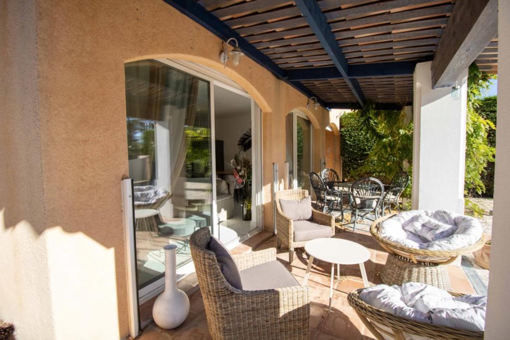 an outdoor patio with wicker chairs and tables at Quiet villa with garden and terrace in Fréjus in Fréjus