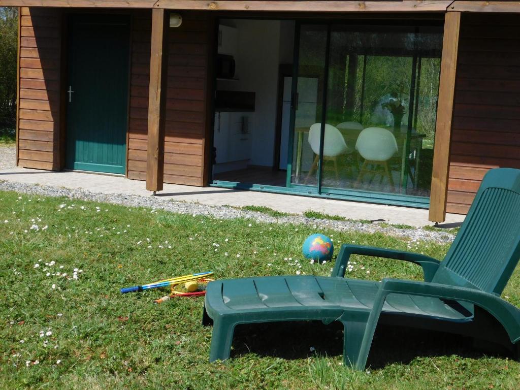 a green lawn chair and a ball at Village de Gîtes Nature et Jardin in Bouère