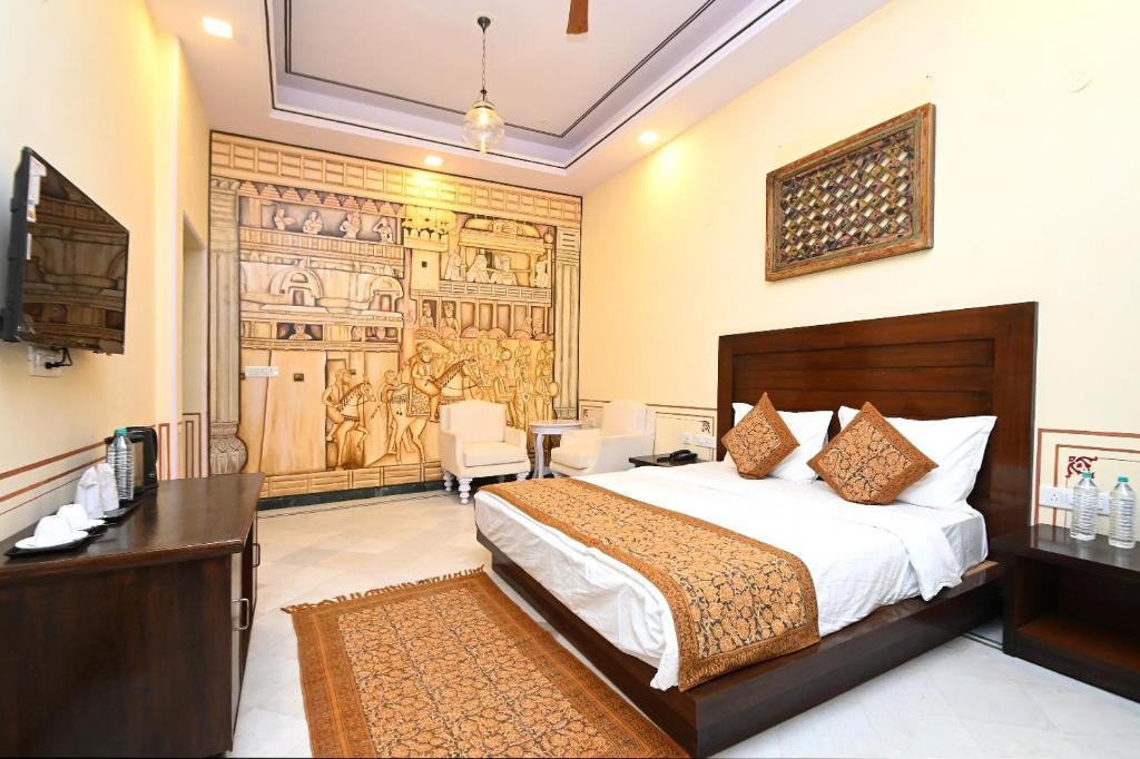 a hotel room with a bed and a desk and a room at Aaram Baagh Maheshwar in Maheshwar