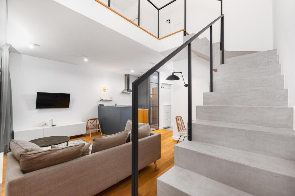 a living room with a staircase and a couch at Pory 57 by Homeprime in Warsaw