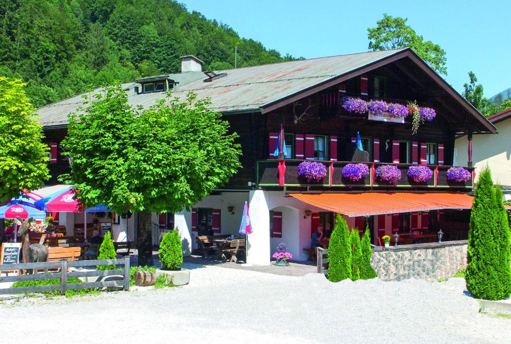 ein Gebäude mit Blumen auf den Balkonen in der Unterkunft Wirtshaus und Pension Hocheck in Ramsau bei Berchtesgaden