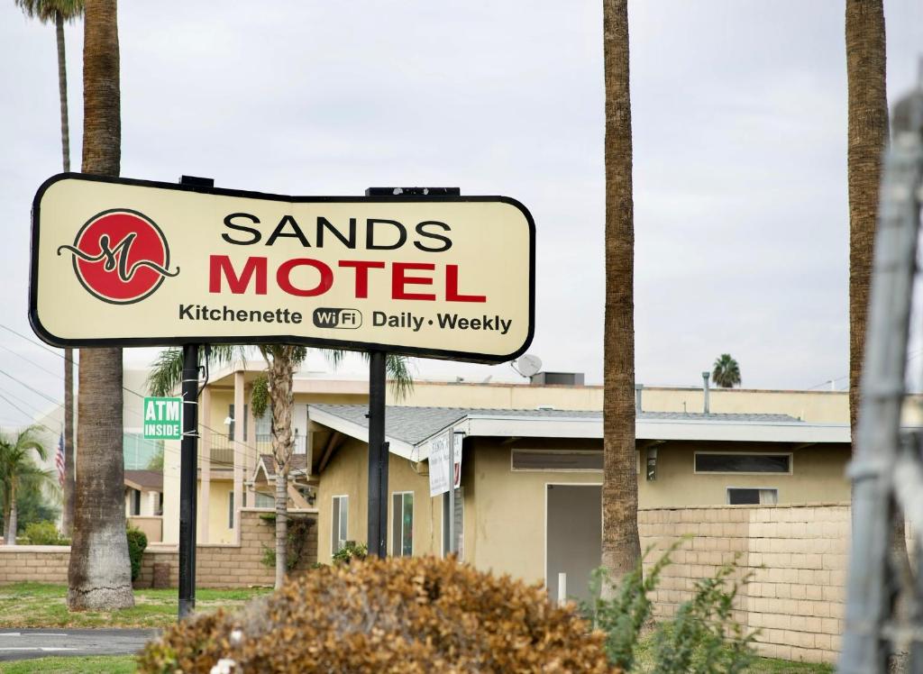 una señal para un motel de arena frente a un edificio en Sands Motel by Ontario Airport & Toyota Arena en Ontario