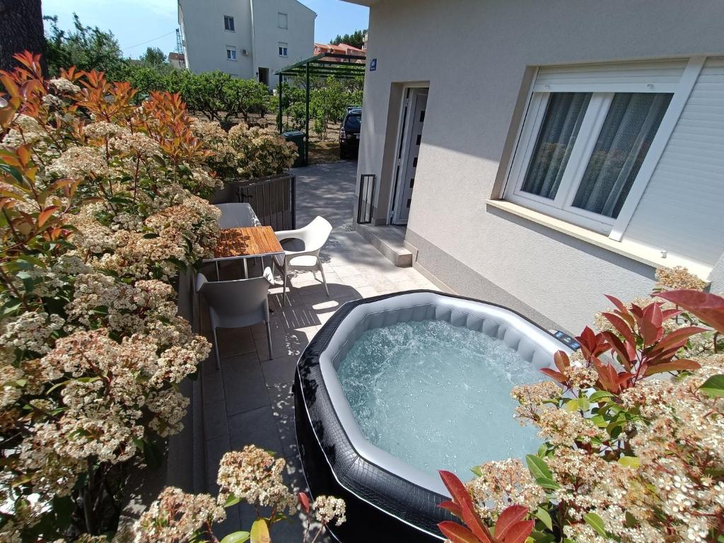 un bain à remous installé sur une terrasse agrémentée de plantes dans l'établissement Holiday Home Relax, à Podstrana
