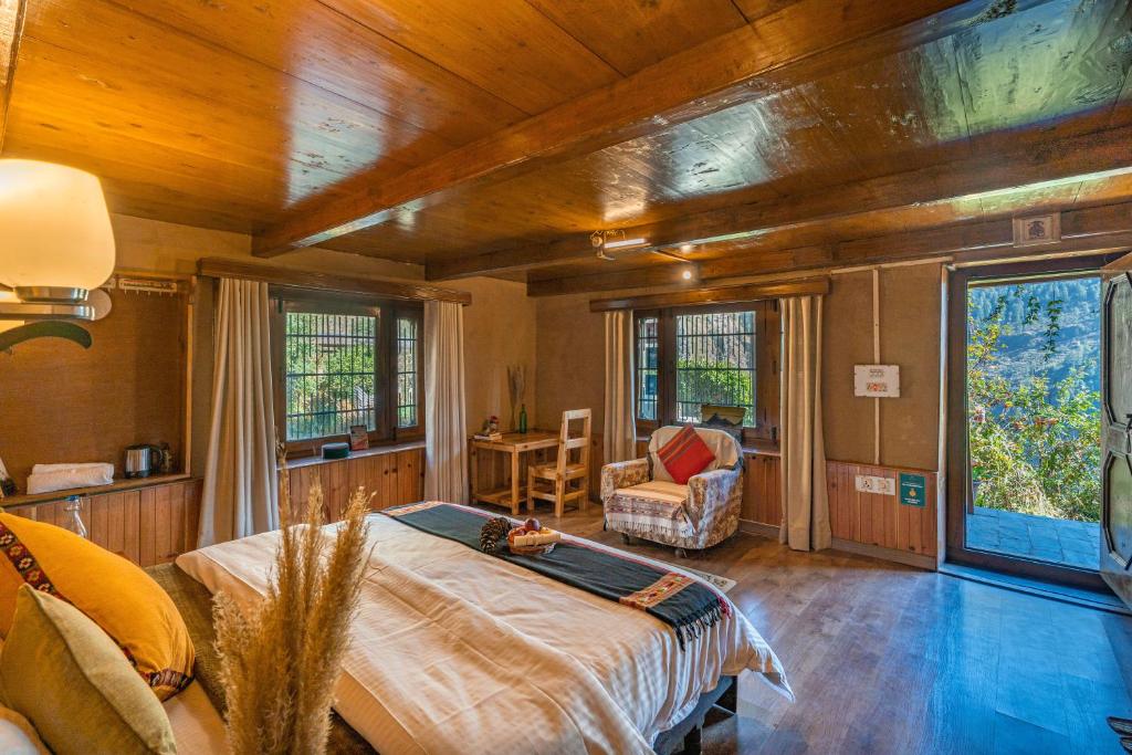 a bedroom with a bed in a room with wooden ceilings at Zostel Homes Laida (Jibhi) in Sainj