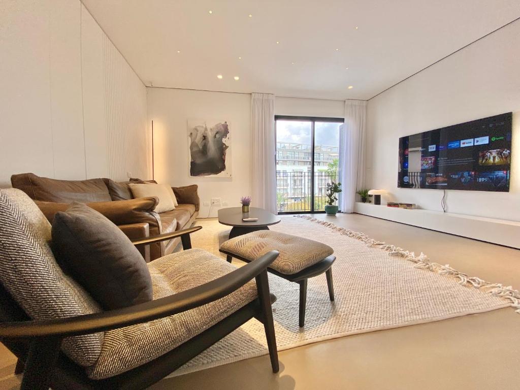 ein Wohnzimmer mit einem Sofa und einem Tisch in der Unterkunft 12 Shimon HaTzadik - By Beach Apartments TLV in Tel Aviv
