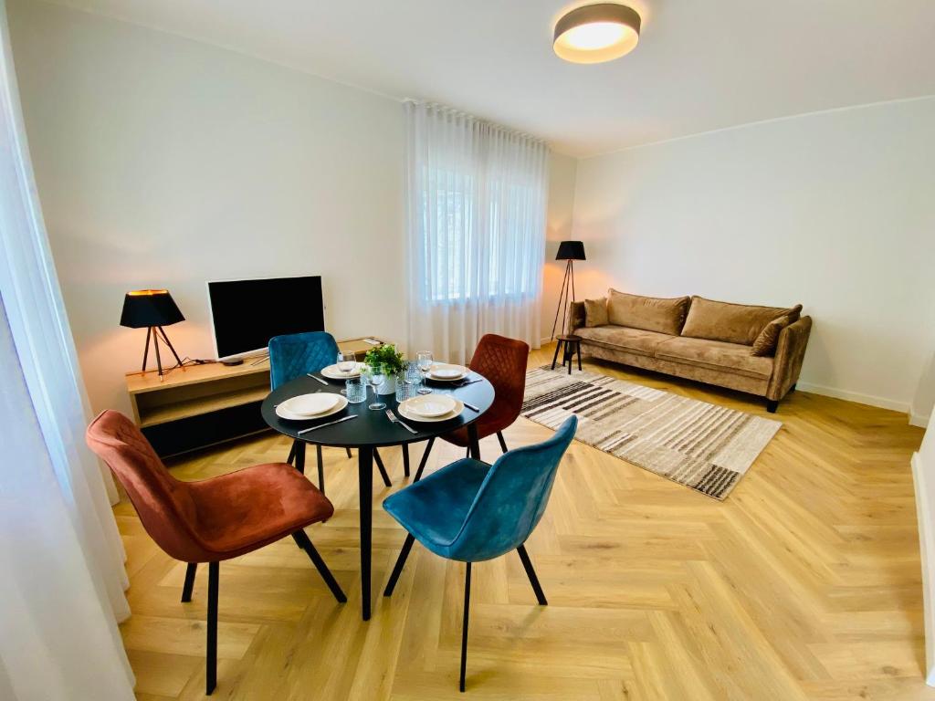 een woonkamer met een tafel en stoelen en een bank bij Cozy Reimani Residence - City Heart Free Parking in Tallinn