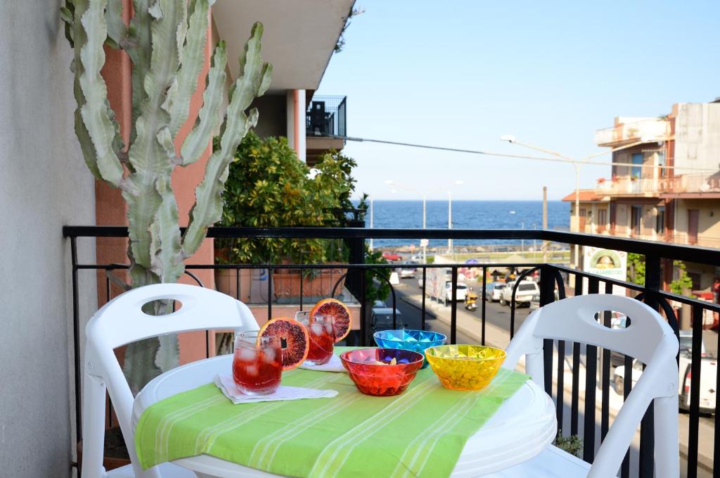 einen Tisch mit Schalen und Tellern auf dem Balkon in der Unterkunft Casa Iolanda in Riposto