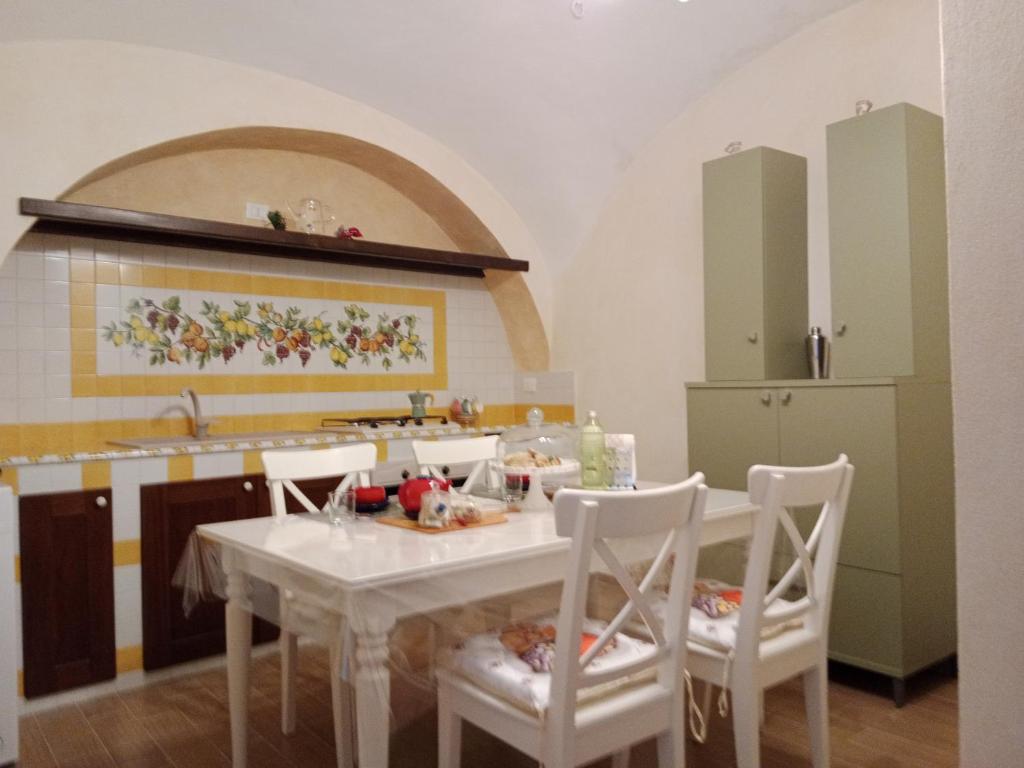 uma cozinha com uma mesa com cadeiras e um lavatório em Creta Rossa em Larino