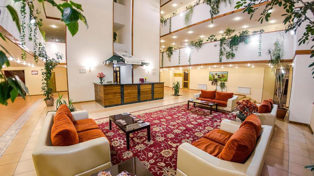 a large lobby with couches and a living room at Reikartz Dostar Karaganda in Karagandy