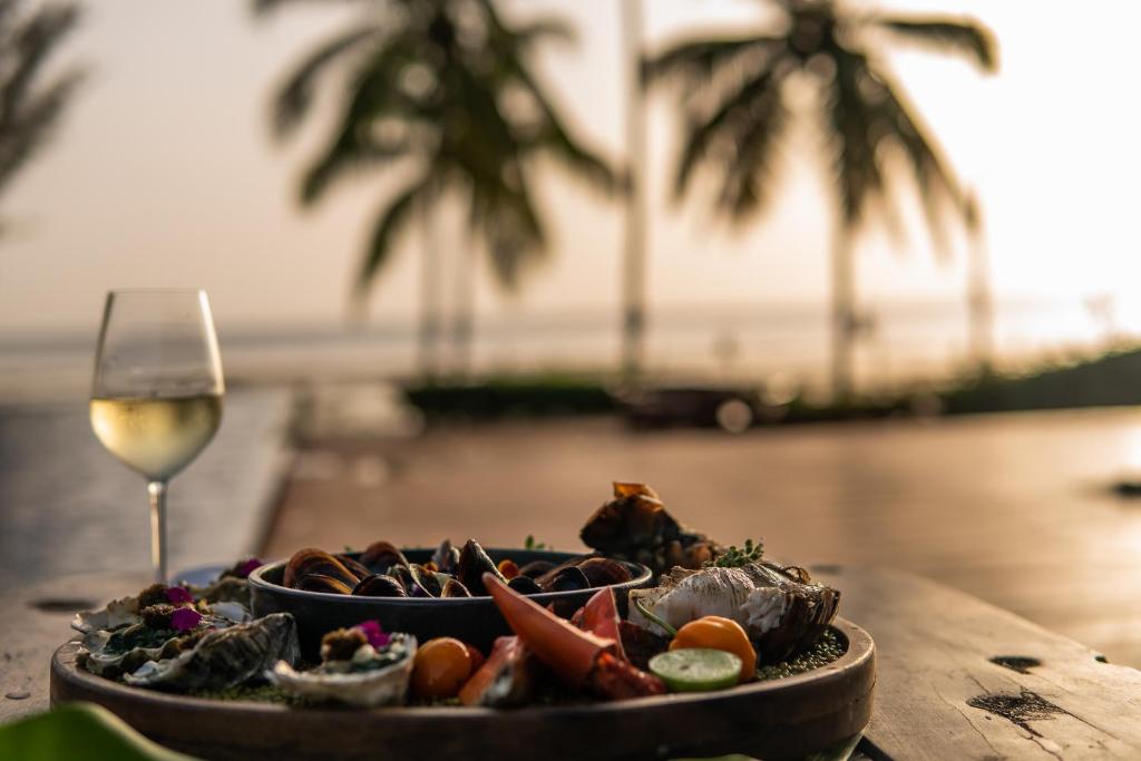 a plate of food on a table with a glass of wine at The Residence Zanzibar in Kizimkazi