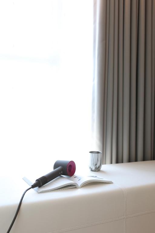 a book and a phone sitting on a radiator at Manho Hotel in Taichung