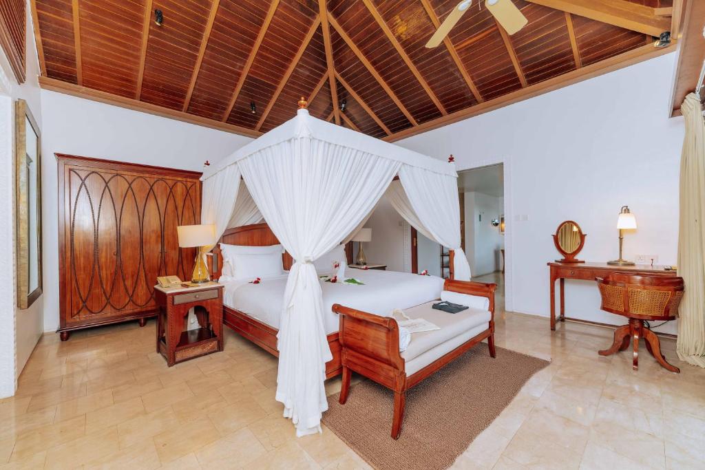 a bedroom with a bed with a canopy at The Residence Zanzibar in Kizimkazi