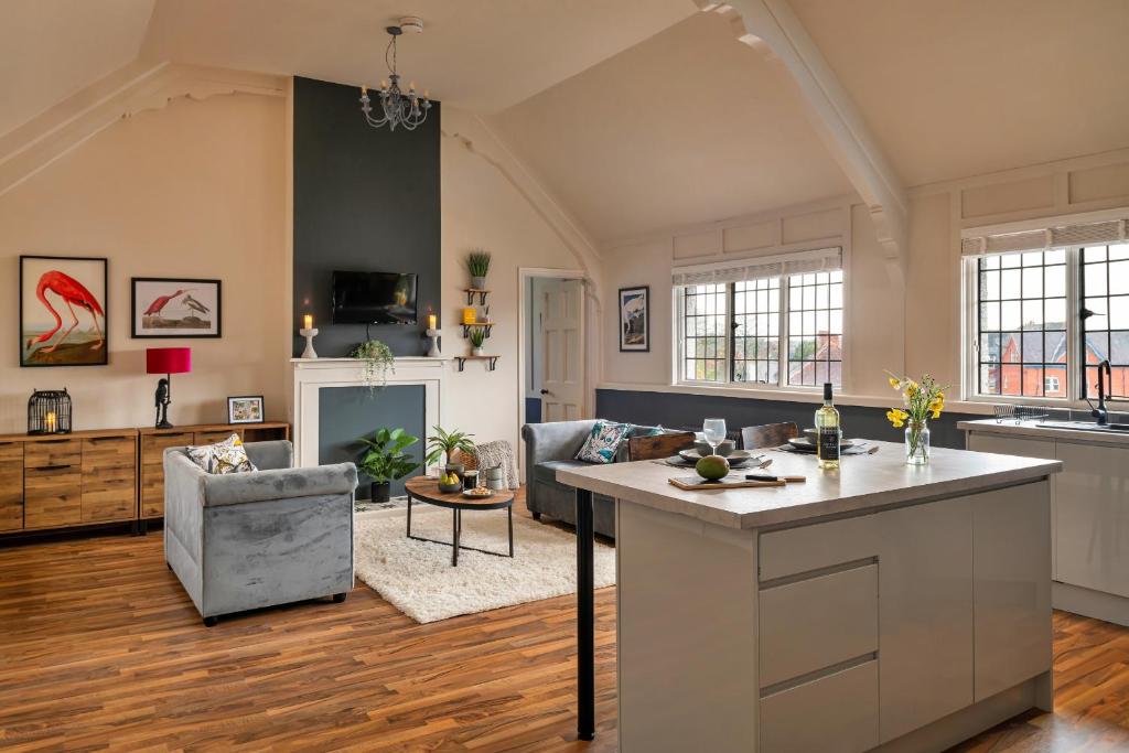 uma cozinha e sala de estar com um sofá e uma mesa em Finest Retreats - Sunnycroft Penthouse em Llandrindod Wells