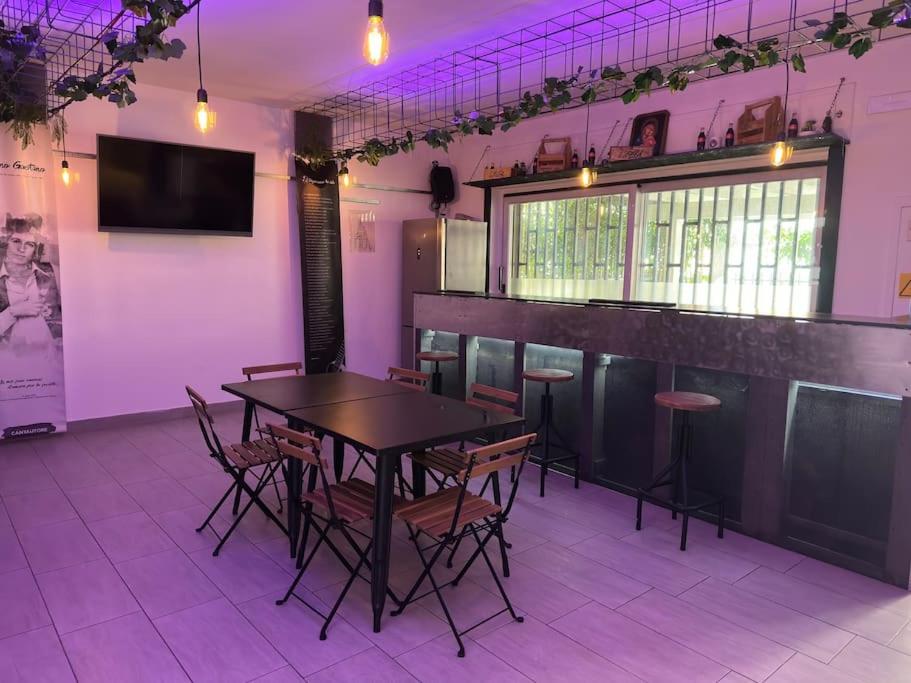 a table and chairs in a room with purple lighting at Appartamento per famiglie o gruppi di amici Access Point in Crotone