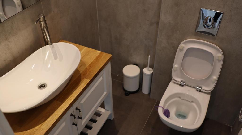 a bathroom with a white sink and a toilet at Lux & Comfy ~ Pool ~ Queen Beds in Rishon LeẔiyyon