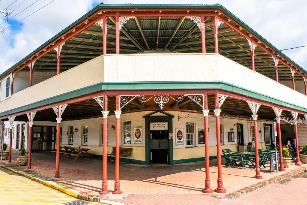 uma estação ferroviária com um edifício com colunas vermelhas em Peel Inn Hotel Nundle em Nundle