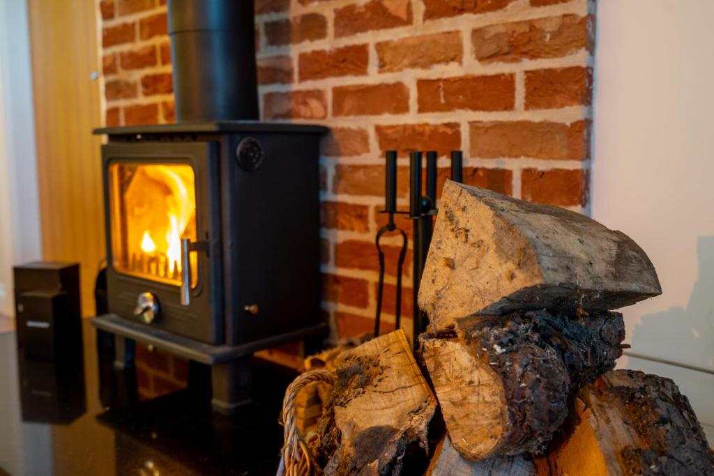 a wood stove with a log in front of it at Brecks Farm - Cow Kennels in York