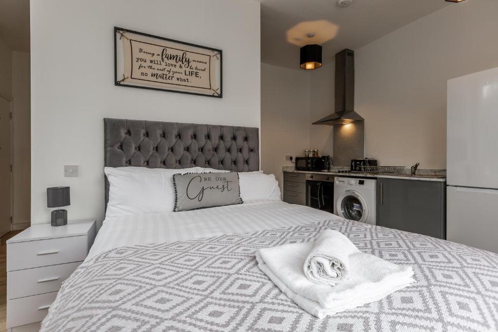 a bedroom with a large white bed and a kitchen at York Villas Free Parking Included in Liverpool