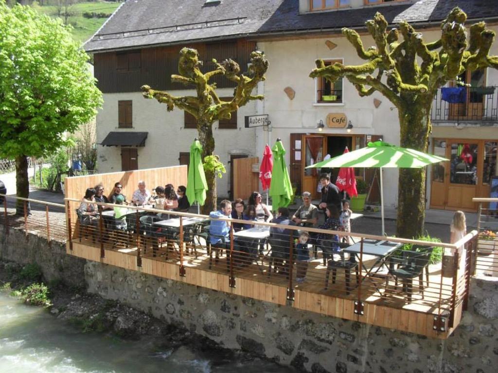 a group of people sitting at a table in front of a building at GITE AUBERGE L'HERBE TENDRE in Saint-Pierre-dʼEntremont