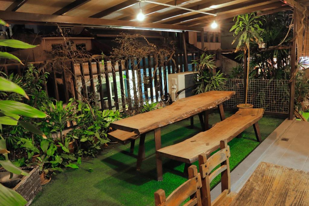 twee houten banken in een kamer met planten bij Rain Forest Hotel in Kuala Lumpur