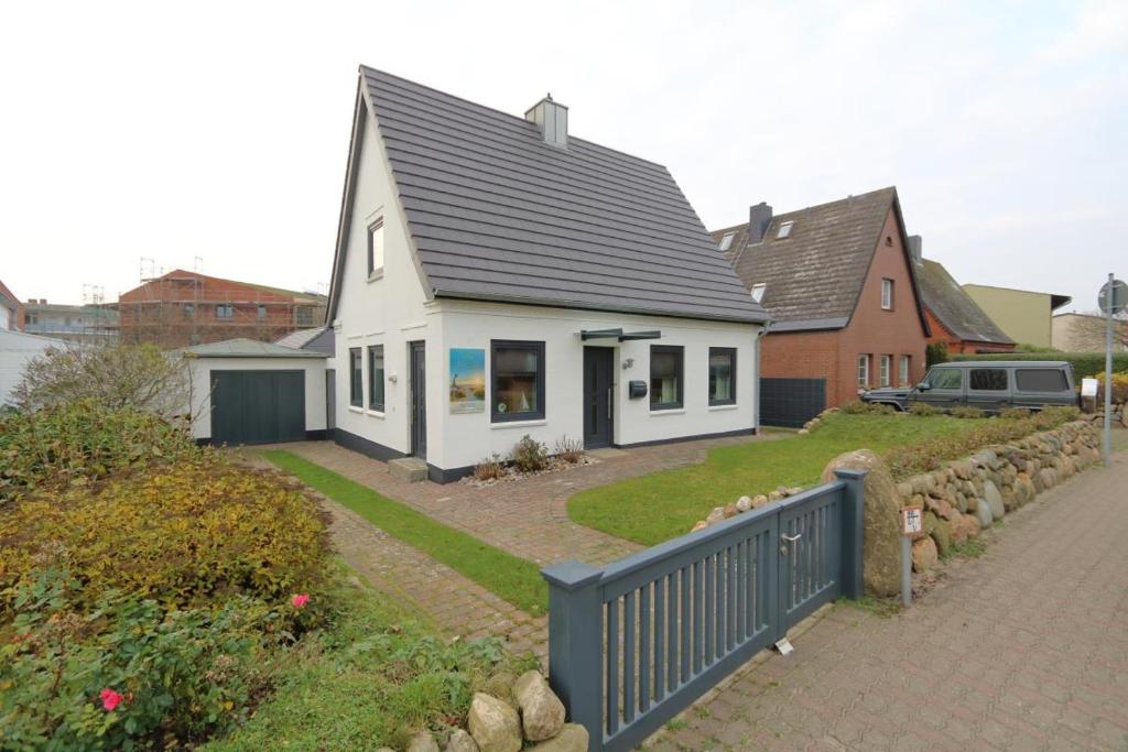 ein weißes Haus mit einem schwarzen Dach und einer Auffahrt in der Unterkunft Solveig Fynn 04 in Westerland