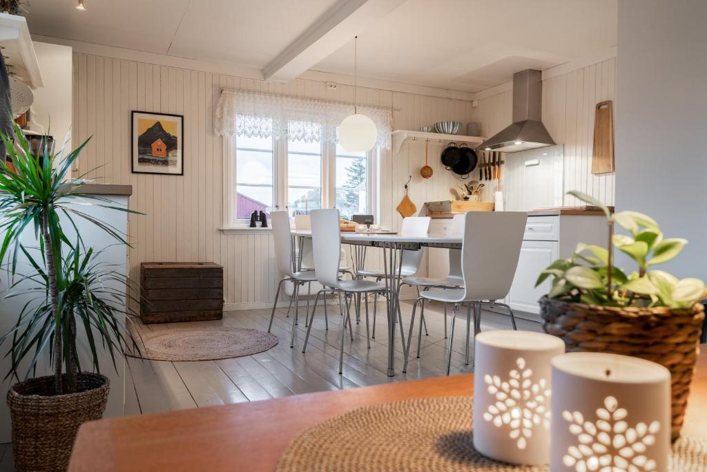 cocina y comedor con mesa y sillas en Lofoten- Fishermans logde with the view, en Stamsund