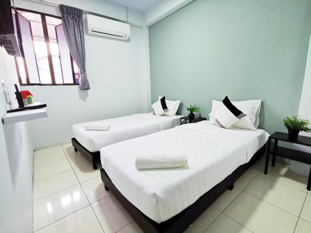 two beds in a room with two windows at Gurney Coast Guest House by Sky Hive in George Town