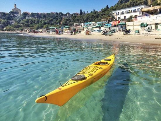新布薩娜的住宿－A marina on Bussana Sanremo seaside，漂浮在海滩附近的水中的一个黄色皮艇
