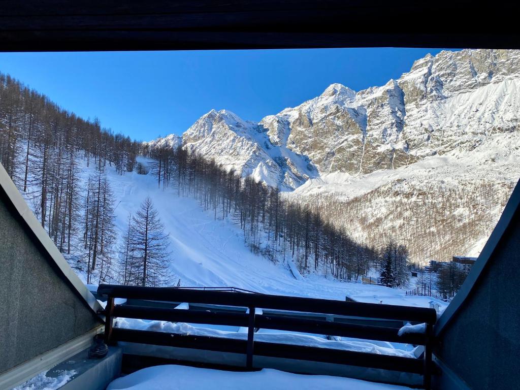 desde un banco con vistas a una montaña nevada en Cervinia Ski In Ski Out - Family Studio, en Breuil-Cervinia