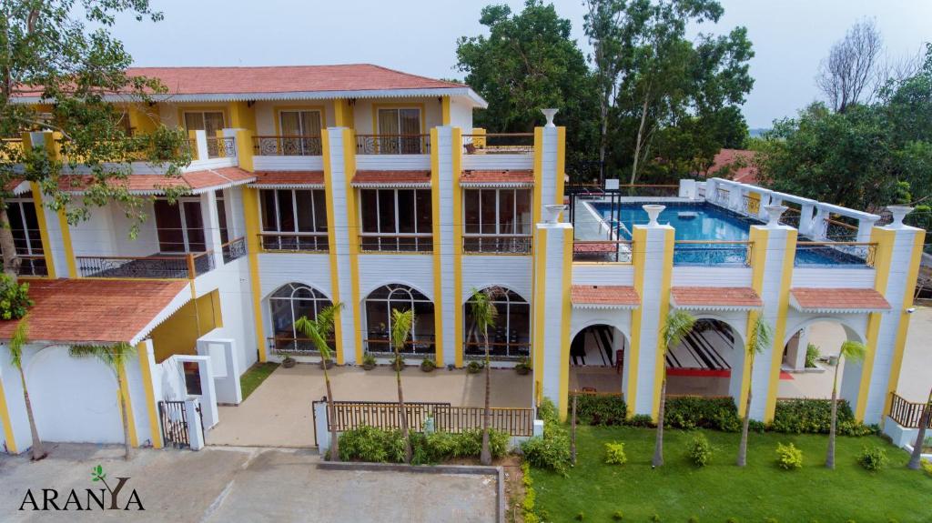 una casa con piscina frente a ella en ARANYA RESORT BOLPUR, en Bolpur
