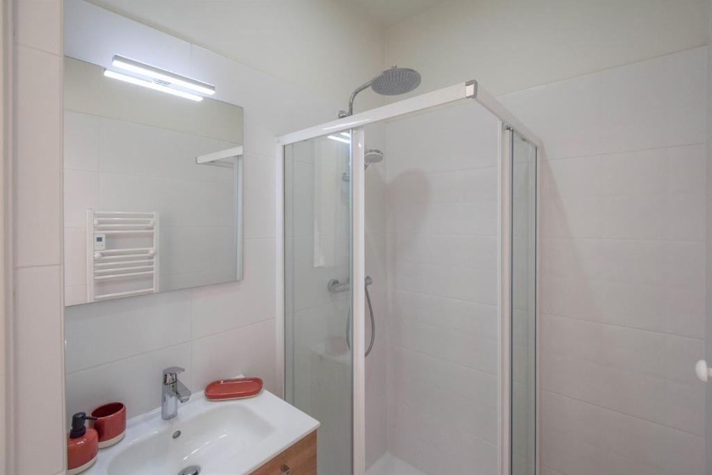 a white bathroom with a shower and a sink at Domaine d&#39;Essendiéras in Saint-Médard-dʼExcideuil