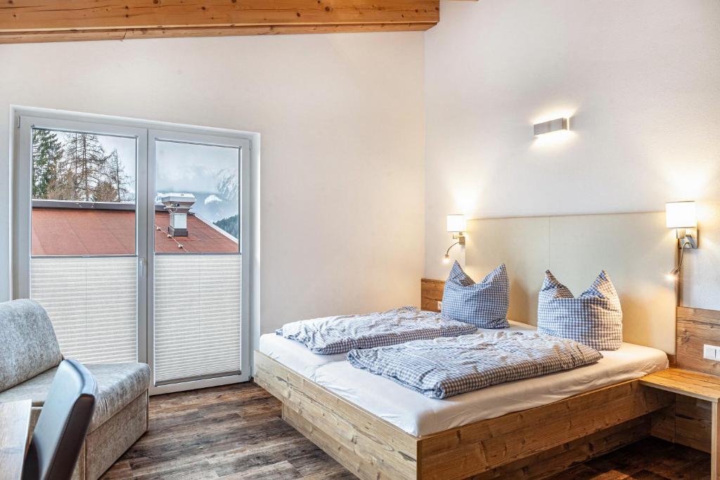 a bedroom with a bed and a large window at Ferienwohnung Wetterstein in Ehrwald