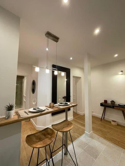 a kitchen with two stools and a counter in a room at Paris15 eme Chic appartement atypique et calme in Paris