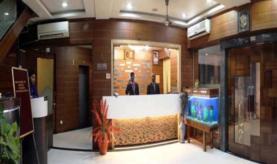 a man standing in a lobby with a fish tank at hotel puneet international in Raipur