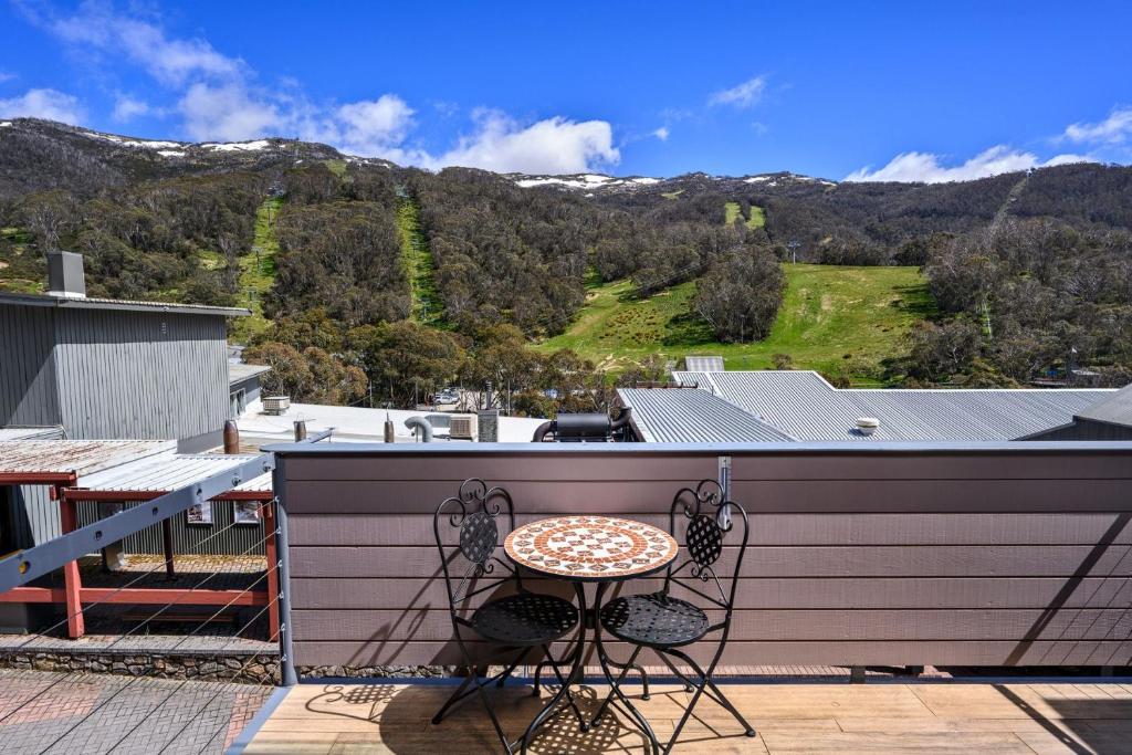 a patio with a table and chairs on a balcony at Squatters Run Unit 11 in Thredbo