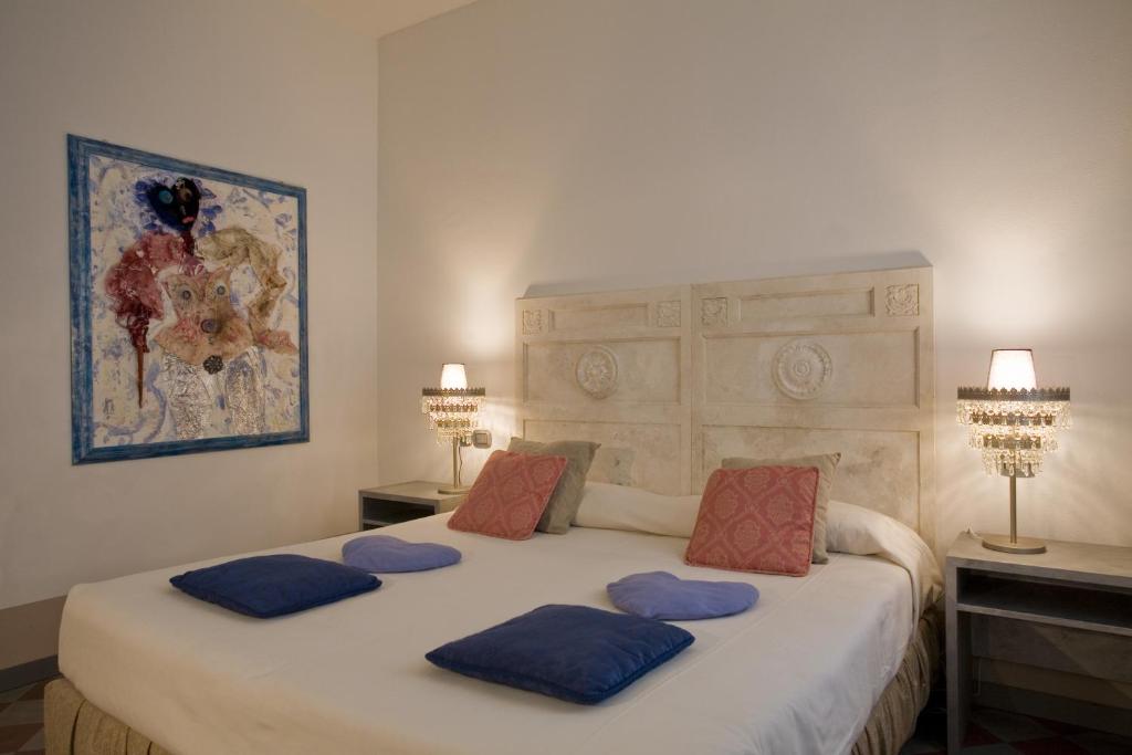 sypialnia z dużym łóżkiem z niebieskimi poduszkami w obiekcie Art Hotel Al Fagiano w Padwie