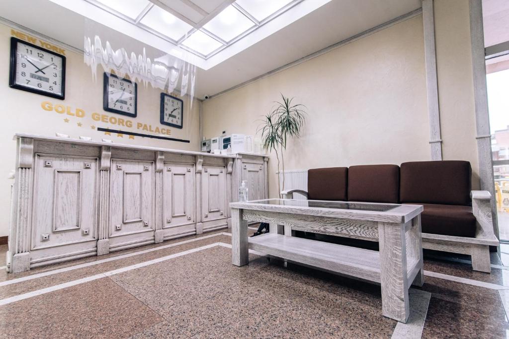 a waiting room with a couch and a table at Gold Georg Palace Hotel in Chernivtsi