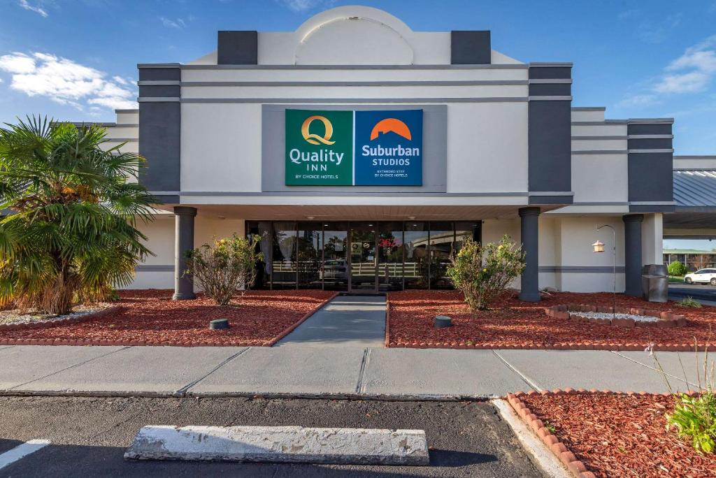 uma loja em frente a um centro comercial com palmeiras em Quality Inn em Rock Hill