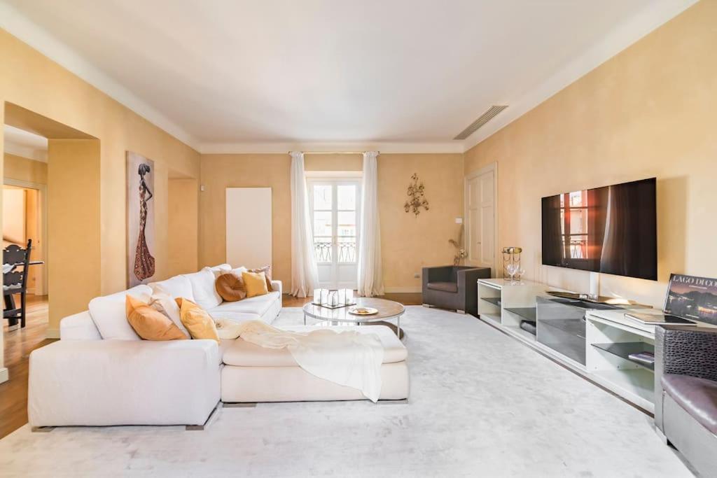 a living room with a white couch and a tv at Santa Giuliana Apartment in Como