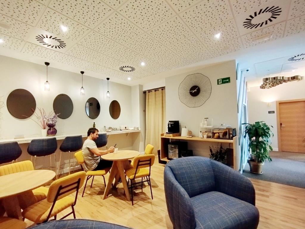a person sitting at a table in a room at Habital Suites in Jaca