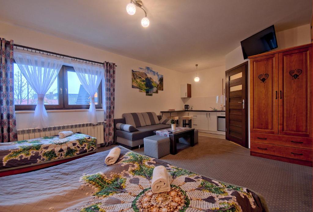una camera d'albergo con due letti e una cucina di POKOJE BUCKI a Bukowina Tatrzańska