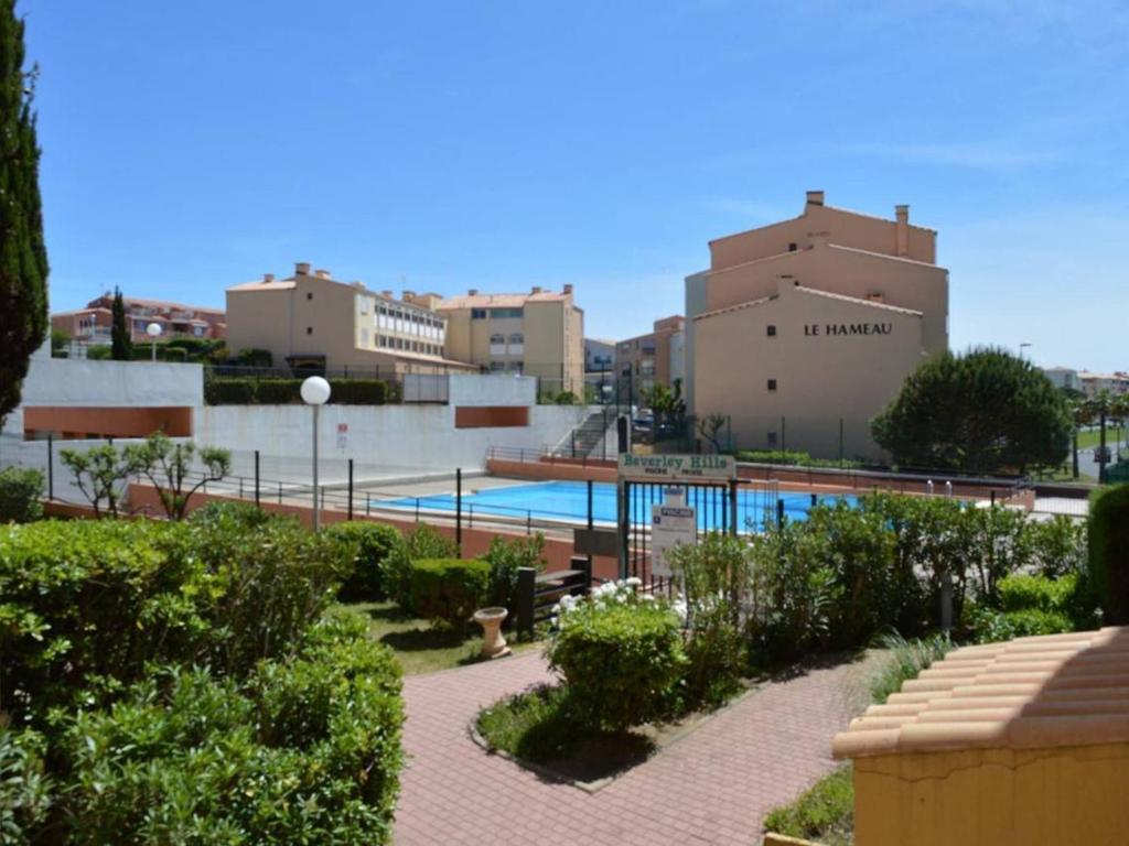 un complexe avec une piscine et des bâtiments dans l'établissement Appartement 3 pièces, piscine, à 100m de la plage, avec garage privatif, Cap d'Agde - FR-1-249-192, au Cap d'Agde