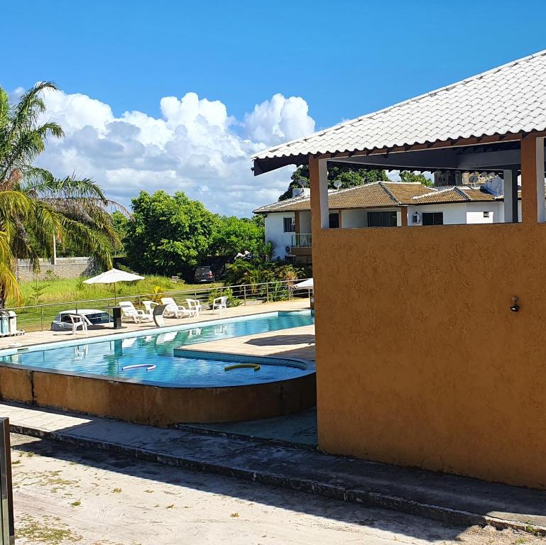 una piscina con sillas y una casa en Casa Mutá, en Porto Seguro