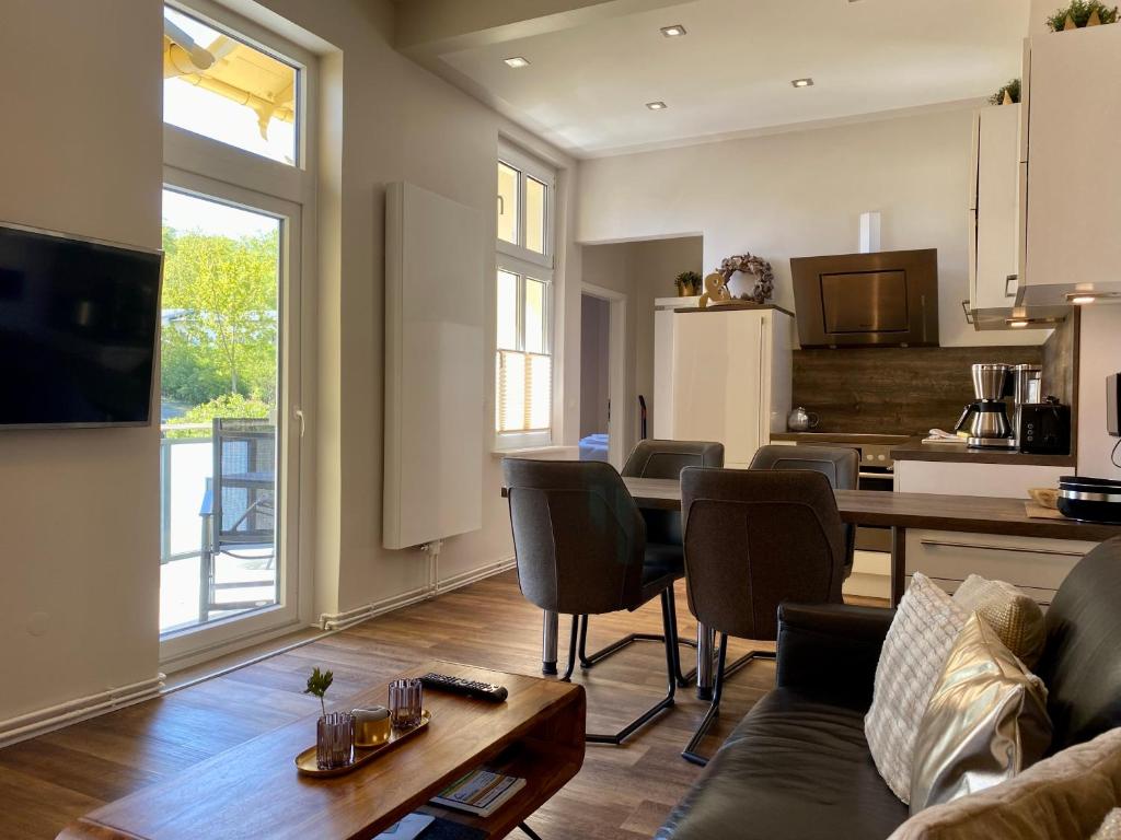 une cuisine et un salon avec une table et des chaises dans l'établissement Villa Anna - Kaiserperle, à Heringsdorf