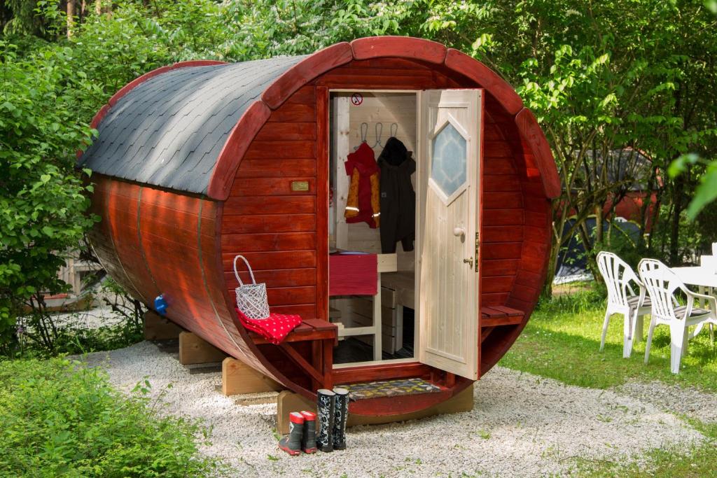 una pequeña casa hobbit de madera en un jardín en Waldcamping Brombach, en Pleinfeld