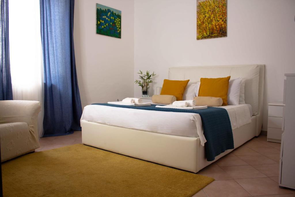 una camera da letto con un grande letto bianco con cuscini gialli di Badia Holiday Home a Taormina