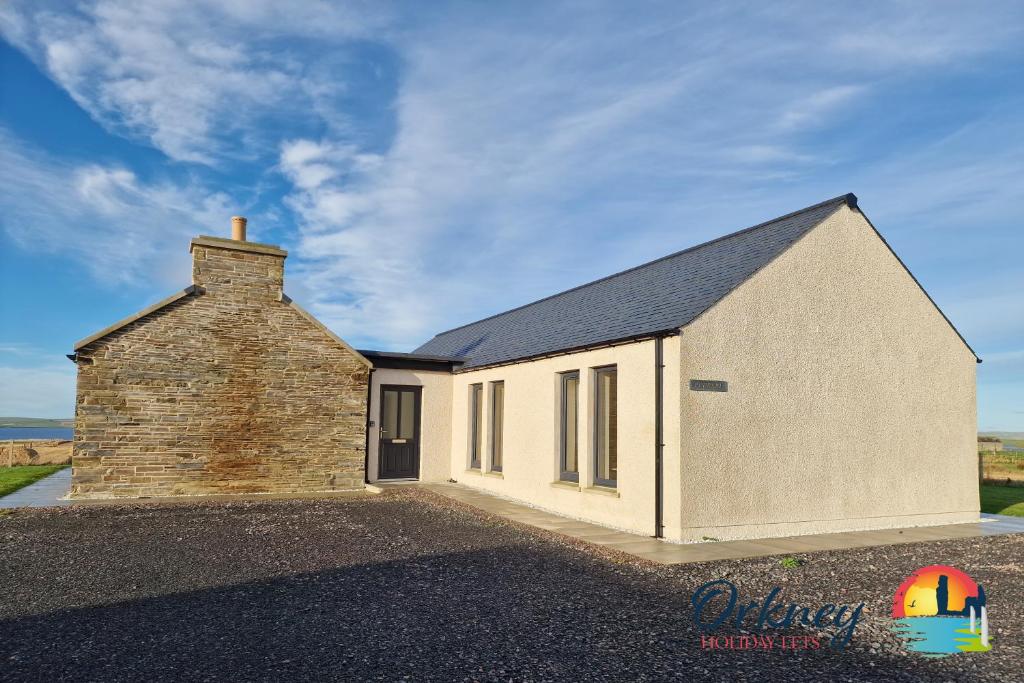 une maison en pierre avec un bâtiment en briques dans l'établissement Burrian - OR00247F, Lyermira - OR00249F, & Kirkquoy - OR00248F, Harray, Orkney, à Orkney